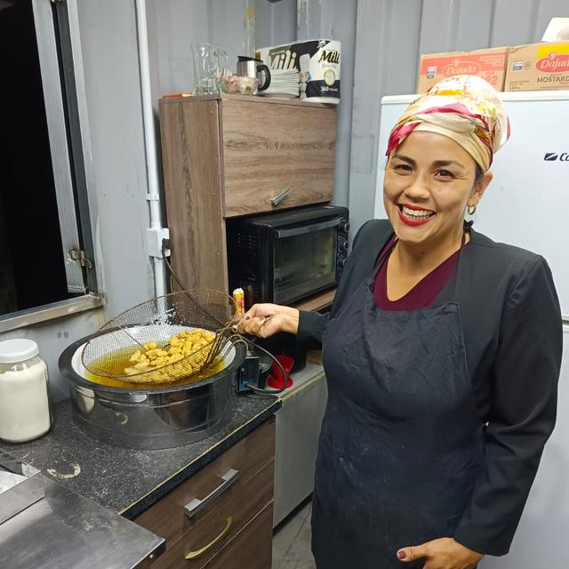Atemisa na cozinha da Toca da Onça, tirando a batata da fritadeira